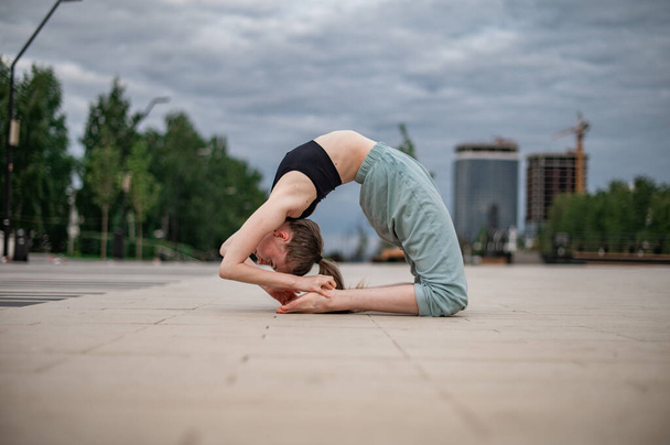 Meisje beoefent yoga en meditatie in de stad. - Foto, afbeelding