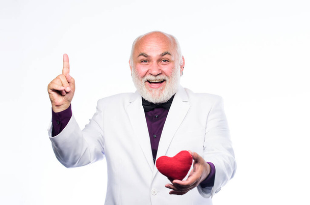 Heart and healthcare. Diagnostics and treatment. Preventing heart attack. Senior bald head bearded man holding red toy heart in hands. Health care. Healthy life. Cheerful man with valentines heart - Foto, Imagem