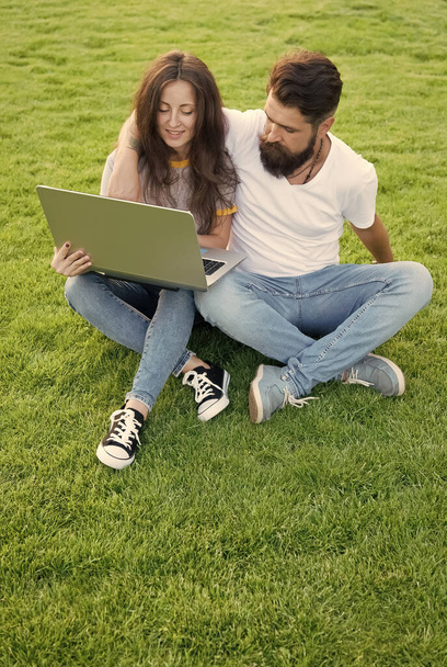 Girl and hipster man with laptop outdoors, web development concept - 写真・画像