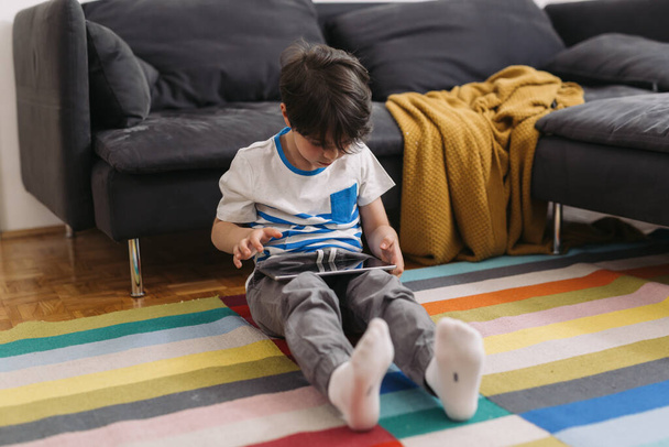 little sitting at home and using digital tablet - Fotoğraf, Görsel