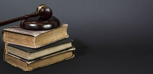 Концепція права - юридична книга з дерев'яними суддями, наданими на столі в залі суду або правоохоронних органах. Копіювати простір для тексту
  - Фото, зображення