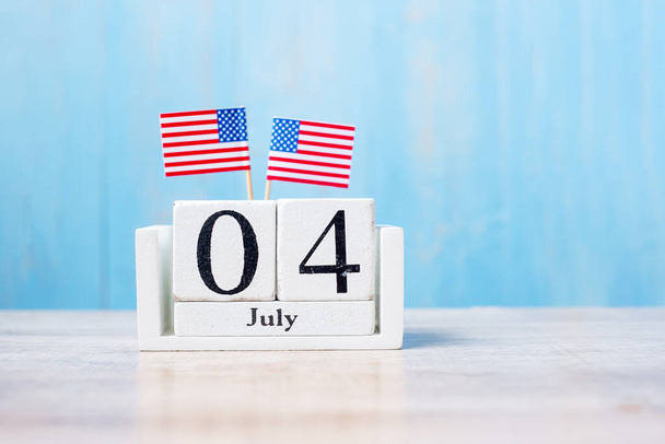Dřevěný kalendář 4. července s miniaturní vlajkou Spojených států amerických na dřevěném pozadí. Den nezávislosti a národ Rekreační koncept - Fotografie, Obrázek