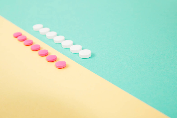 Λευκά και ροζ φάρμακα σε ένα έγχρωμο διπλό φόντο - Φωτογραφία, εικόνα