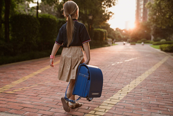 Возвращайся в школу. Маленькая девочка с прогулки в начальной школе. Ребенок собирается узнать новые вещи 1 сентября - Фото, изображение