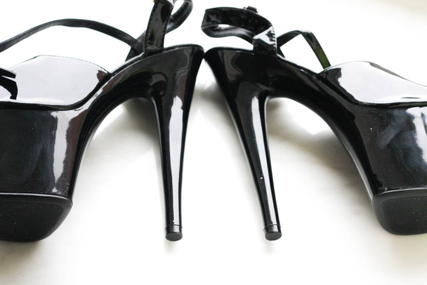 Tiras de charol negro / zapatos de tacón alto sobre fondo blanco - Foto, imagen