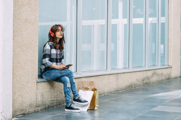 Woman listening to music while waiting for someone. - Foto, afbeelding