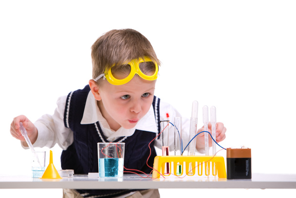 Crazy scientist. Young boy performing experiments with battery and small lamp. - Foto, afbeelding