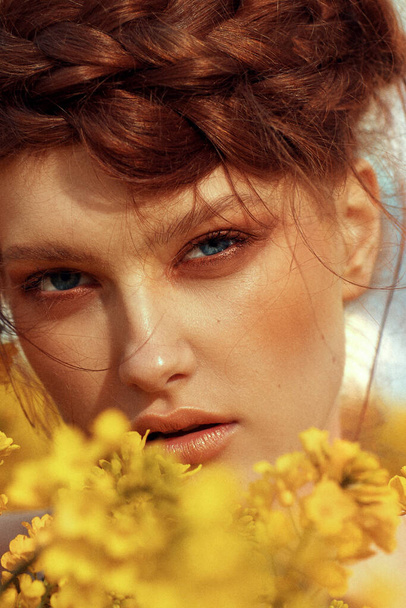  Retrato de modelo de moda joven con pelo de jengibre y ojos azules en campo de colza amarillo - Foto, Imagen