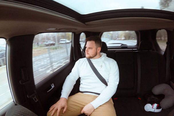 Mann schnallt sich mit Sicherheitsgurt hinten im Auto an Besorgnis-Stimmung - Foto, Bild