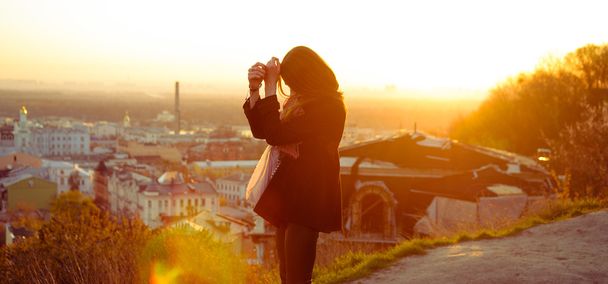 Brunette girl standing against the city background - Foto, immagini