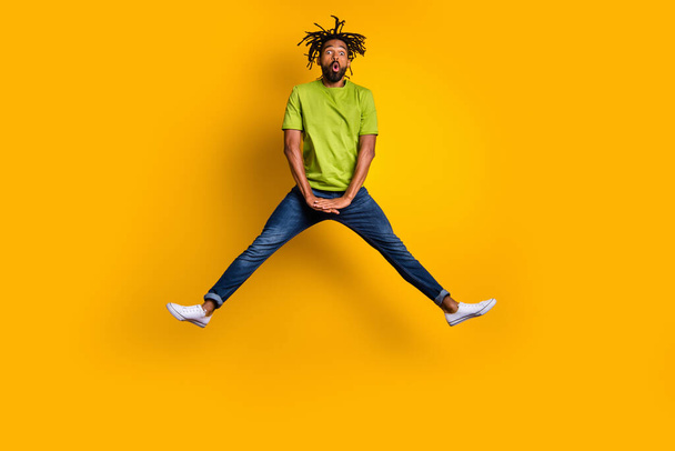 Photo portrait full body view of shocked man jumping up spreading legs isolated on vivid yellow colored background - Photo, Image