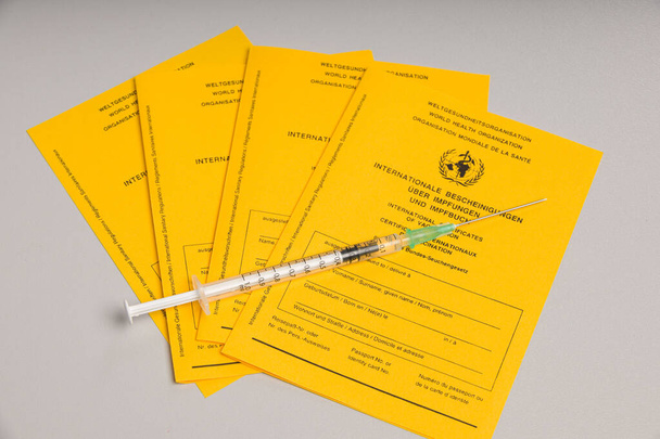 niektóre międzynarodowe świadectwa szczepień i strzykawka ze szczepionką przeciw kovidowi-19 - Zdjęcie, obraz