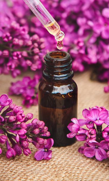 Huile essentielle de lilas dans une petite bouteille. Concentration sélective. Nature. - Photo, image