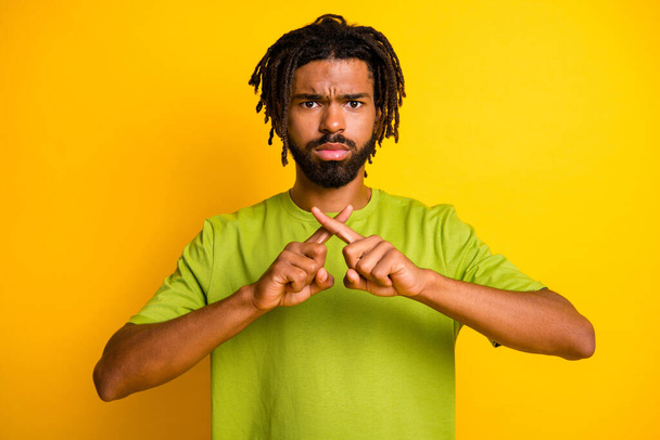 Photo of serious afro american guy cross index fingers stop block signal isolated over bright yellow color background - Foto, imagen