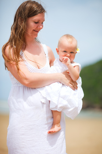 Young mother and baby girl walking on the beach - Foto, imagen