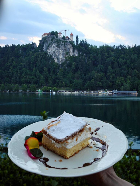Lago di Bled, il Castello di Bled e specialità culinarie della zona, una pasticceria alla panna (kremna rezina o kremnita Cremeschnitte). Designato piatto protetto di origine designata dal governo sloveno. - Foto, immagini