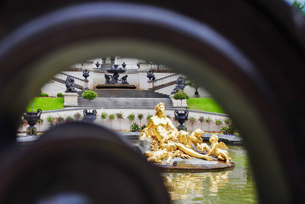 LINDERHOF, ALEMANHA: Palácio Linderhof (alemão: Schloss Linderhof) em Ettal, Baviera. O parterre da água na frente do palácio é dominado por uma bacia grande com o grupo dourado da fonte "Flora e puttos." - Foto, Imagem