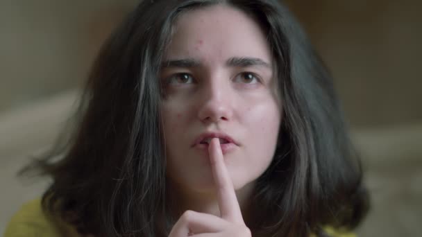 close-up van een meisje gezicht zet haar vinger naar haar lippen, een teken van stilte - Video