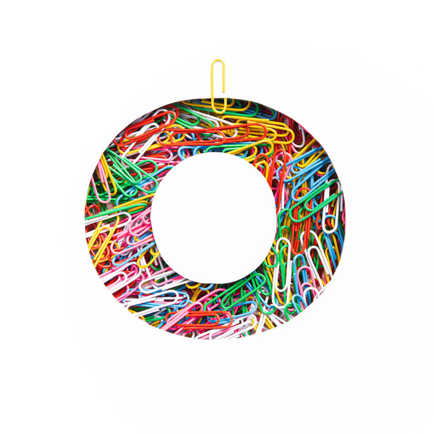 Alphabet of colourful paperclips. Letter O of English abc, paper clips, white cut sheet. Typeface of office supplies - 写真・画像