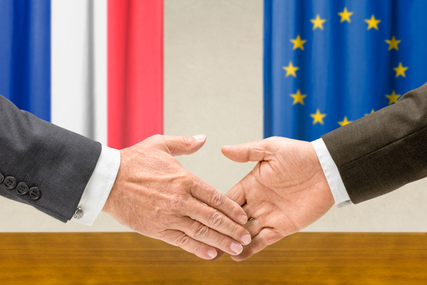 Representantes da França e da UE apertam a mão
 - Foto, Imagem
