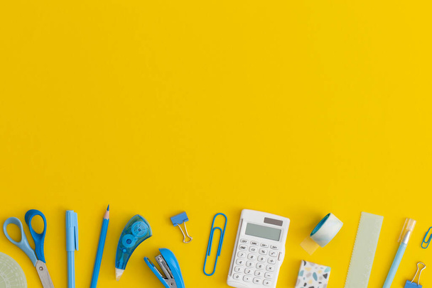 School stationery on a yellow background. Top view with copy space. Flat lay. Back to school concept. - 写真・画像