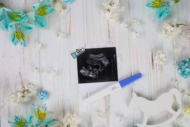 Baby ultrasound and pregnancy test on wood background. Child planning. Pregnancy concept. - Photo, Image