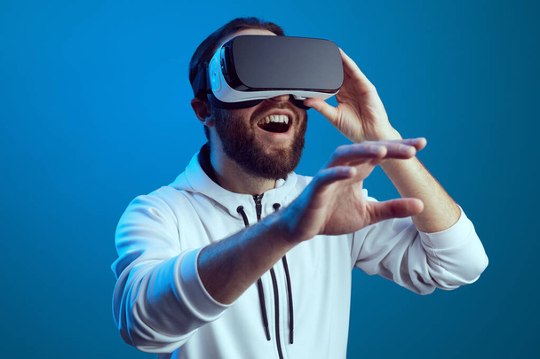 Hämmästynyt nuori mies koskettaa ilmaa aikana VR kokemus - Valokuva, kuva