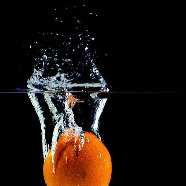 one green apple falling into water on a white background with splashes, drops and bubbles - 写真・画像