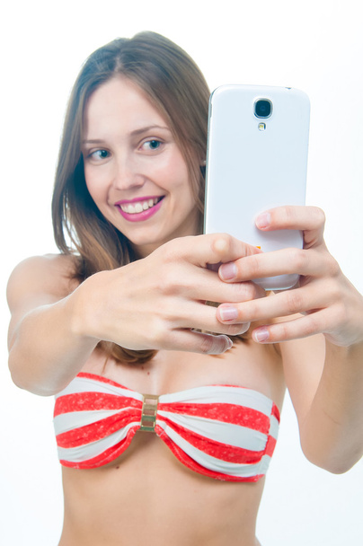 Beautiful woman in bikini  taking picture on her phone - Zdjęcie, obraz