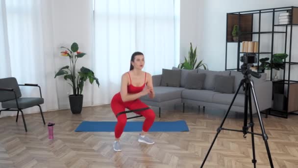 Спорт м'язиста жінка записує онлайн урок курсу на камеру, тренування вдома
 - Кадри, відео