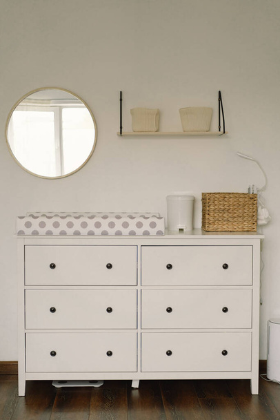 Baby room interior design. Chest of drawers with changing pad and tray in nursery. Infant baby room. - Photo, Image