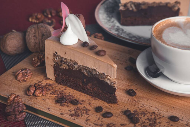 Beautiful Slice of a Smooth and Delicious chocolate cake. With other plates around it and a sprinkle of coffee and chocolate chips around it. Is also has a dollop of whipped cream... - Φωτογραφία, εικόνα