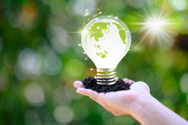 Main humaine tenant ampoule économiseuse d'énergie et sauver le concept du monde, concept de journée mondiale de l'environnement, sauver le monde et le concept d'éco entreprise - Photo, image