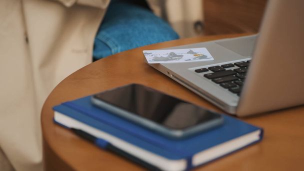 Primer plano de chica estudiante que utiliza el ordenador portátil para pagar en línea con tarjeta de crédito durante el descanso cooffee en la cafetería al aire libre. Concepto de tecnología moderna - Foto, Imagen