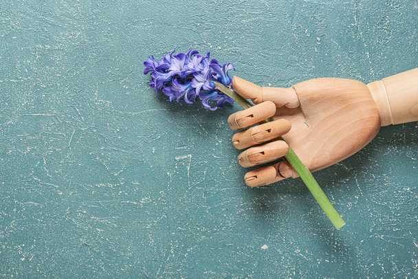 Деревянная рука с гиацинтом на цветном фоне - Фото, изображение
