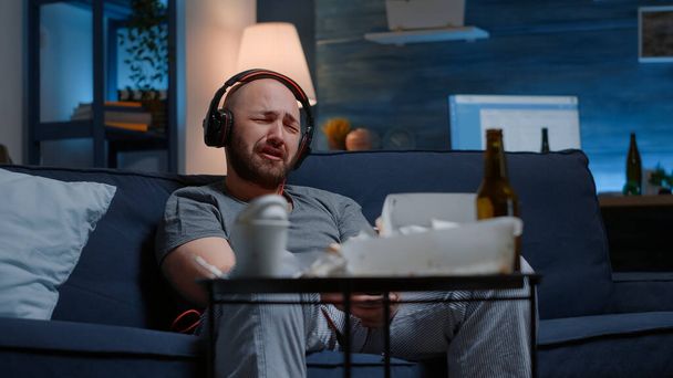 Безнадежный депрессивный человек слушает грустную музыку в наушниках - Фото, изображение