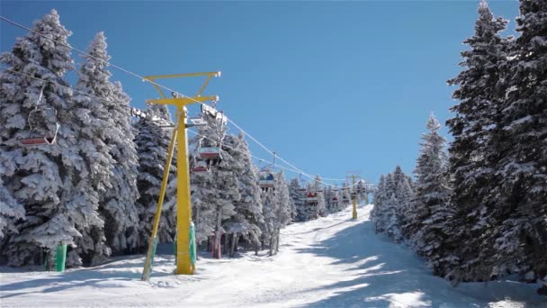 Wyciąg narciarski najeżdża na ośnieżonych górskich i timelapse promień słońca. - Materiał filmowy, wideo