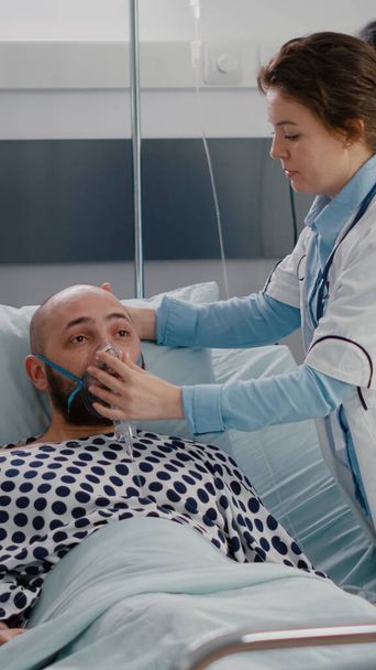 Lékařský tým monitoruje srdeční tep nemocného muže během respirační pohotovosti - Fotografie, Obrázek