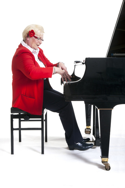 Старша леді в червоному грає на піаніно
 - Фото, зображення