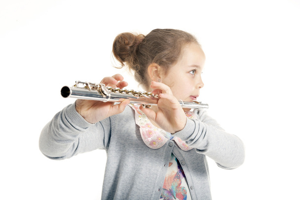 Молодая девушка играет на флейте
 - Фото, изображение