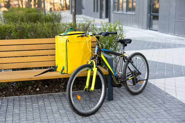 Fast bicycle courier. big yellow bag and bicycle - Foto, Bild