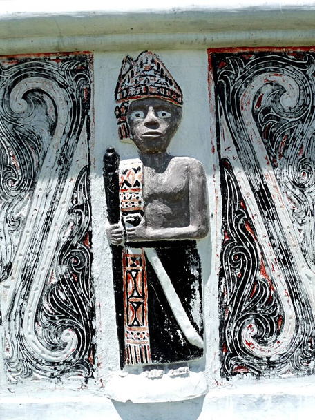 Carving of figure of Batak hunter with traditional colours and design of that ethnic group from the Indonesian island of Sumatra. High quality photo - Photo, Image