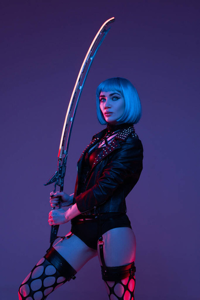 Combative cyberpunk woman with sword indoors studio - Photo, Image