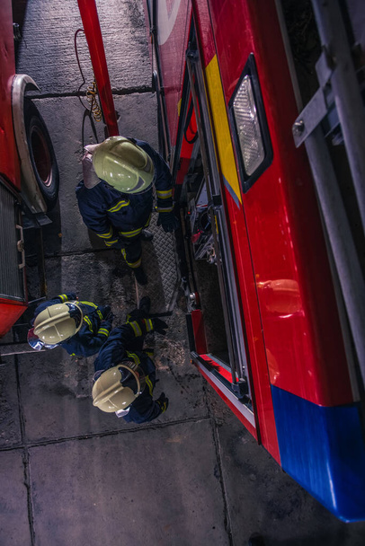 Palomiehet tarkastavat paloauton palokunnan sisällä lintuperspektiivistä - Valokuva, kuva