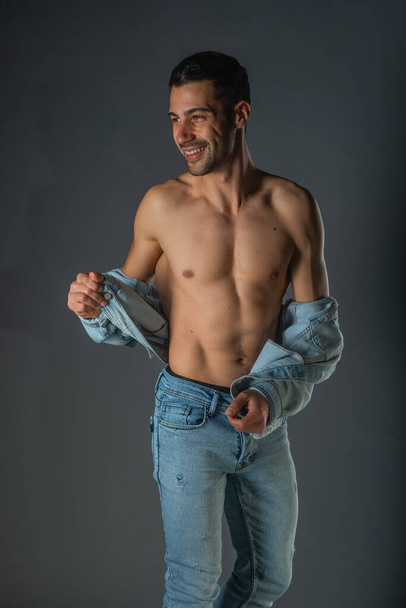 Hezký svalnatý muž bez trička stojí sebevědomě, profil pohled, dívá se do kamery - Fotografie, Obrázek