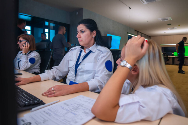 Ana kontrol odasında otururken bilgisayar başında çalışan kadın güvenlik görevlileri. - Fotoğraf, Görsel