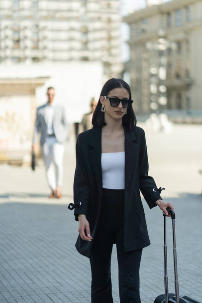 Casual dressed female boss is thinking about the offer while walking with her assistents behind her - Fotografie, Obrázek