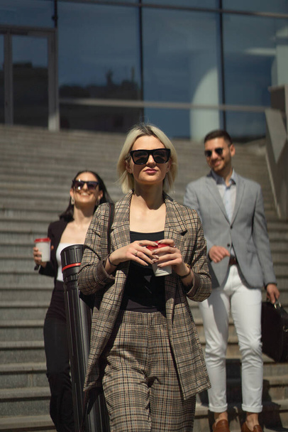 Three casual dressed business partners are going down the stairs - Photo, Image