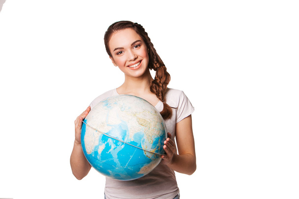 Pretty smiling young woman holding a world globe - Valokuva, kuva