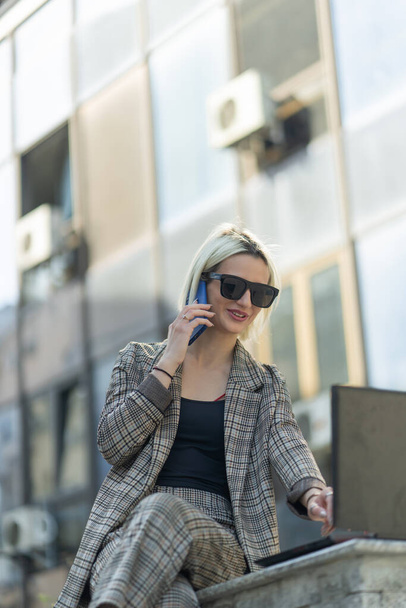 Empresária está satisfeita com a conversa no telefone, enquanto ela está piorando em seu lapotop - Foto, Imagem